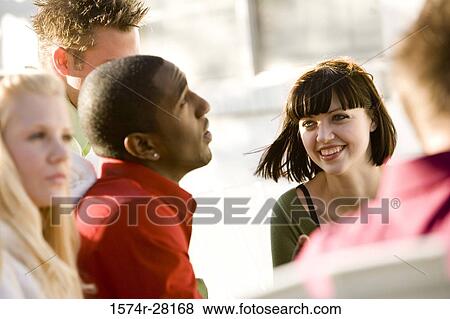 Friends sitting on armchairs and smiling View Large Photo Image Stock Photo - Friends sitting on armchairs and smiling. Fotosearch