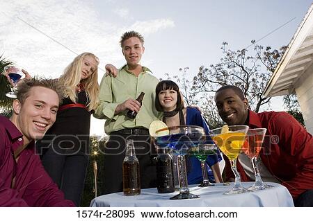 Friends sitting with wineglass and enjoying drink View Large Photo Image Stock Photography - Friends sitting with wineglass and enjoying drink. Fotosearch