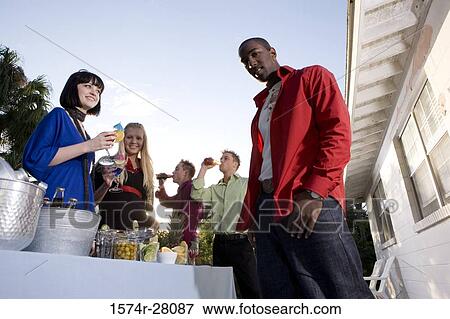 Friends standing with wineglass by house View Large Photo Image Stock Photo - Friends standing with wineglass by house. Fotosearch