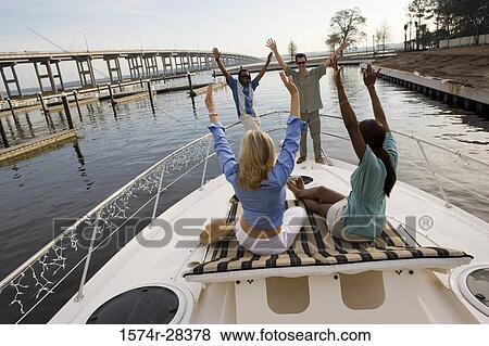 Friends with arms raised on the deck of a boat View Large Photo Image Stock Photo - Friends with arms raised on the deck of a boat. Fotosearch