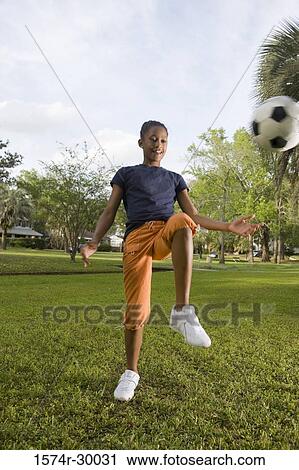 Girl bouncing soccer ball at park View Large Photo Image Stock Image - Girl bouncing soccer ball at park. Fotosearch