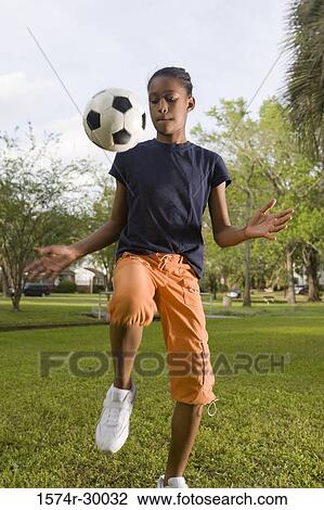 Girl bouncing soccer ball at park View Large Photo Image Stock Image - Girl bouncing soccer ball at park. Fotosearch