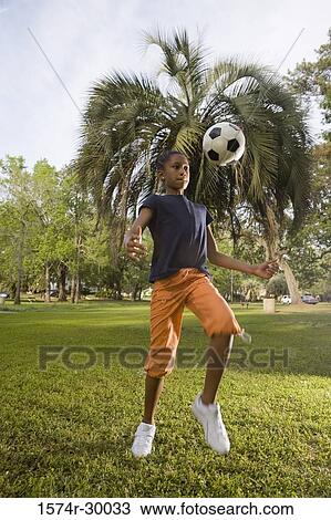 Girl bouncing soccer ball at park View Large Photo Image Stock Image - Girl bouncing soccer ball at park. Fotosearch