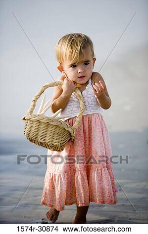 Girl holding basket and standing on the beach View Large Photo Image Picture - Girl holding basket and standing on the beach. Fotosearch