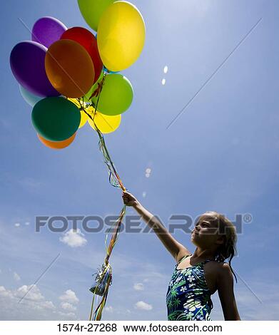Stock Photo - Girl in swim wear holding balloons. Fotosearch