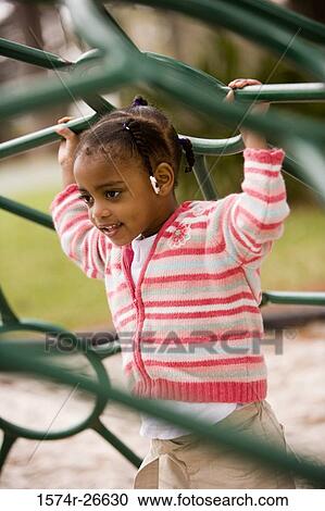 Girl playing on jungle gym at park View Large Photo Image Stock Image - Girl playing on jungle gym at park. Fotosearch