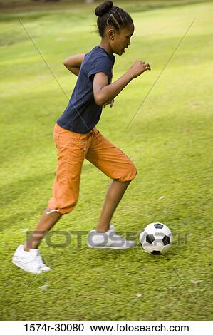 Girl playing with a soccer ball at park View Large Photo Image Stock Image - Girl playing with a soccer ball at park. Fotosearch