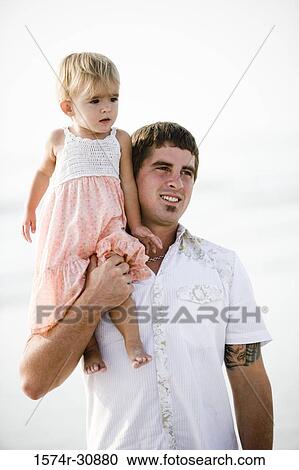 Girl sitting on father's shoulder at beach View Large Photo Image Stock Image - Girl sitting on father's shoulder at beach. Fotosearch