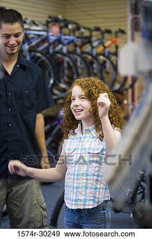 Girl with a man in a bicycle shop View Large Photo Image Stock Photo - Girl with a man in a bicycle shop. Fotosearch
