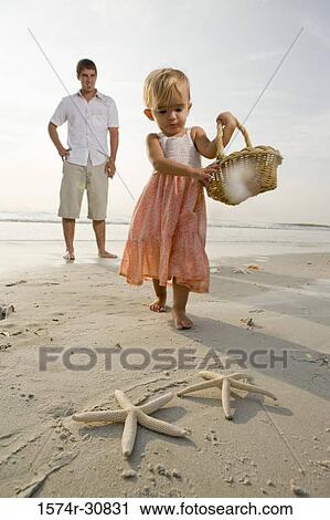 Girl with father playing at beach View Large Photo Image Stock Image - Girl with father playing at beach. Fotosearch