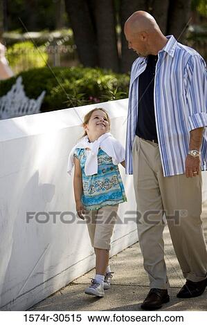 Girl with father walking on a street View Large Photo Image Stock Photography - Girl with father walking on a street. Fotosearch