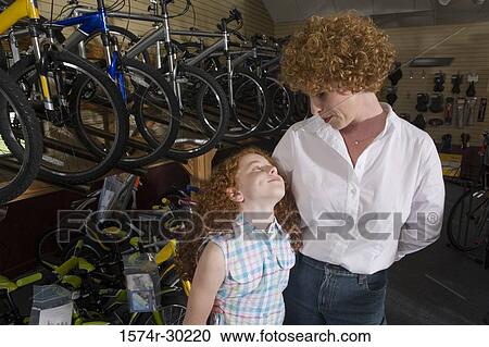 Girl with her mother in a bicycle shop View Large Photo Image Stock Image - Girl with her mother in a bicycle shop. Fotosearch
