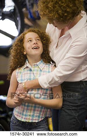 Girl with her mother in a bicycle shop View Large Photo Image Stock Image - Girl with her mother in a bicycle shop. Fotosearch