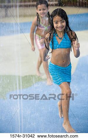 Stock Image - Girls playing under shower. Fotosearch