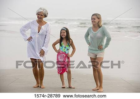 Stock Photo - Grandmother enjoying with her daughter and granddaughter at the beach. Fotosearch