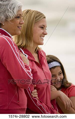 Stock Image - Grandmother with her daughter and granddaughter smiling at the beach. Fotosearch