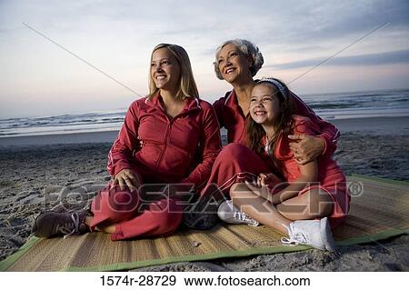 Grandmother with her daughter and granddaughter sitting on a mat at the beach View Large Photo Image Stock Photo - Grandmother with her daughter and granddaughter sitting on a mat at the beach. Fotosearch