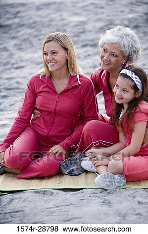 Grandmother with her daughter and granddaughter sitting on a mat at the beach View Large Photo Image Stock Photo - Grandmother with her daughter and granddaughter sitting on a mat at the beach. Fotosearch