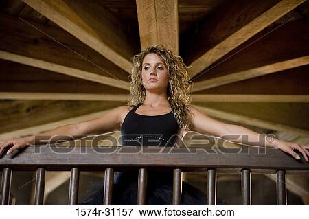 Low angle view of a ballet dancer standing by wooden railing View Large Photo Image Stock Photo - Low angle view of a ballet dancer standing by wooden railing. Fotosearch