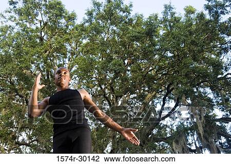Low angle view of a young man running under the trees View Large Photo Image Stock Image - Low angle view of a young man running under the trees. Fotosearch