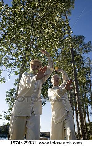 Low angle view of mature couple practicing martial arts View Large Photo Image Stock Image - Low angle view of mature couple practicing martial arts. Fotosearch