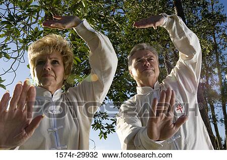 Low angle view of mature couple practicing martial arts View Large Photo Image Stock Image - Low angle view of mature couple practicing martial arts. Fotosearch