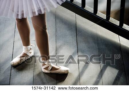 Stock Image - Low section of a young woman practicing ballet dancing. Fotosearch