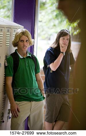Male students standing by locker in corridor View Large Photo Image Stock Photo - Male students standing by locker in corridor. Fotosearch