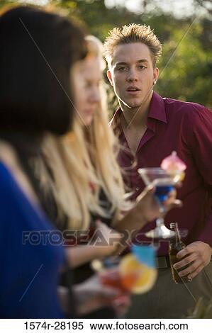Man and women with drinks outdoors View Large Photo Image Stock Photography - Man and women with drinks outdoors. Fotosearch