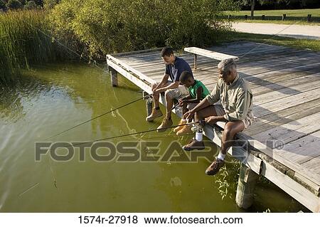 Man fishing with his son and friend on jetty View Large Photo Image Stock Photo - Man fishing with his son and friend on jetty. Fotosearch