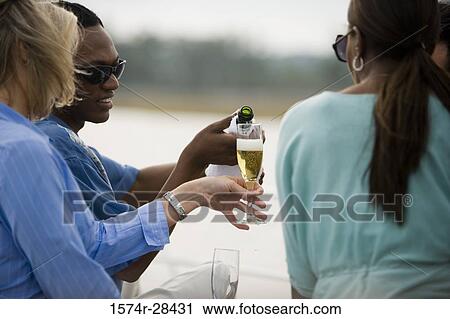Man pouring champagne in woman's glass View Large Photo Image Stock Image - Man pouring champagne in woman's glass. Fotosearch