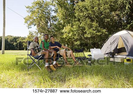 Man with his son and friend conversing by tent at forest View Large Photo Image Stock Photo - Man with his son and friend conversing by tent at forest. Fotosearch
