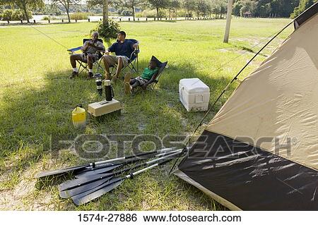 Man with his son and friend conversing by tent at forest View Large Photo Image Stock Photograph - Man with his son and friend conversing by tent at forest. Fotosearch