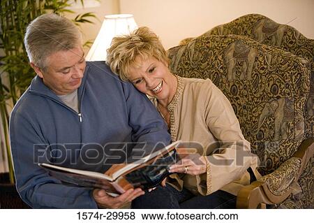 Stock Photo - Mature couple holding a book and smiling. Fotosearch