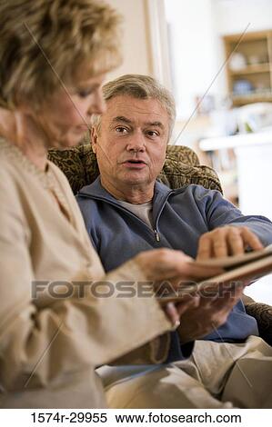 Mature couple holding a book and talking View Large Photo Image Stock Photography - Mature couple holding a book and talking. Fotosearch