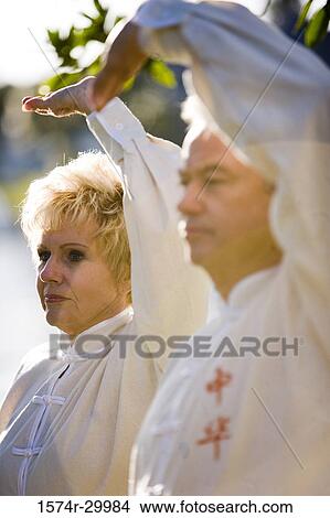 Picture - Mature couple performing martial arts in the park. Fotosearch