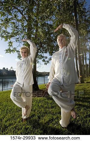 Stock Image - Mature couple practicing martial arts in a park. Fotosearch