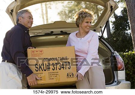 Mature couple removing a cardboard box from a car View Large Photo Image Stock Photography - Mature couple removing a cardboard box from a car. Fotosearch