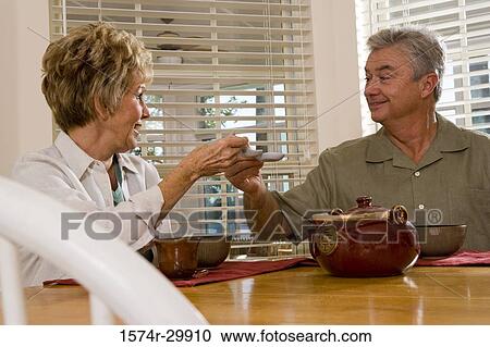 Mature couple sitting at breakfast table and having soup View Large Photo Image Stock Image - Mature couple sitting at breakfast table and having soup. Fotosearch
