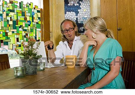 Stock Image - Mature couple sitting together using a laptop. Fotosearch