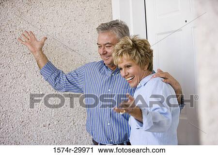 Mature couple standing together and smiling View Large Photo Image Stock Image - Mature couple standing together and smiling. Fotosearch