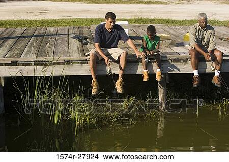 Mature man fishing with his son and friend on jetty View Large Photo Image Picture - Mature man fishing with his son and friend on jetty. Fotosearch