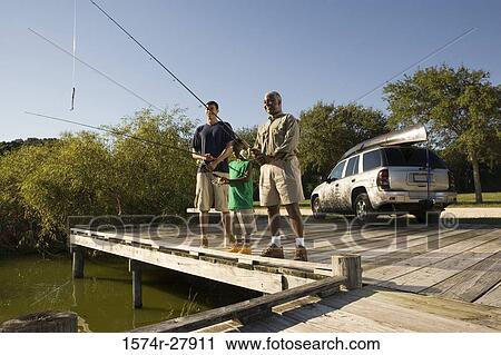 Mature man fishing with his son and friend on jetty View Large Photo Image Stock Image - Mature man fishing with his son and friend on jetty. Fotosearch