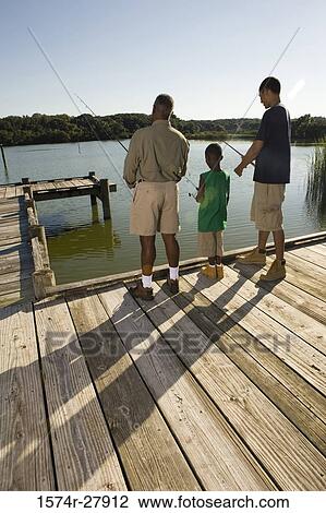 Mature man fishing with his son and friend by lake View Large Photo Image Stock Image - Mature man fishing with his son and friend by lake. Fotosearch