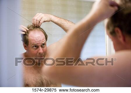 Mature man looking at his face in the bathroom mirror View Large Photo Image Stock Photography - Mature man looking at his face in the bathroom mirror. Fotosearch
