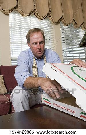 Mature man removing a pizza from a box View Large Photo Image Stock Photography - Mature man removing a pizza from a box. Fotosearch