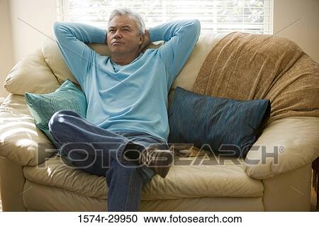 Stock Image - Mature man sitting on a couch. Fotosearch