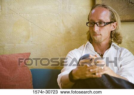 Mature man sitting with hands clasped and looking away View Large Photo Image Stock Image - Mature man sitting with hands clasped and looking away. Fotosearch