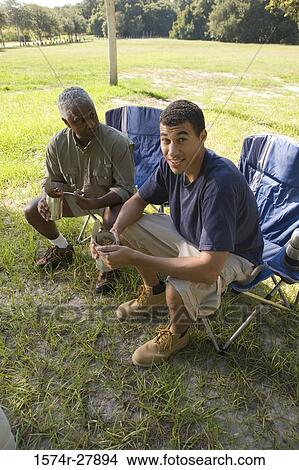 Mature man sitting with his friend on chair at forest View Large Photo Image Picture - Mature man sitting with his friend on chair at forest. Fotosearch