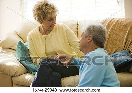 Stock Photo - Mature man talking to a woman in a living room. Fotosearch